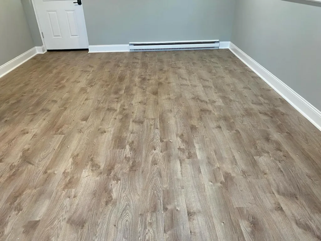 Basement flooring installation completed with vinyl plank flooring and clean edges