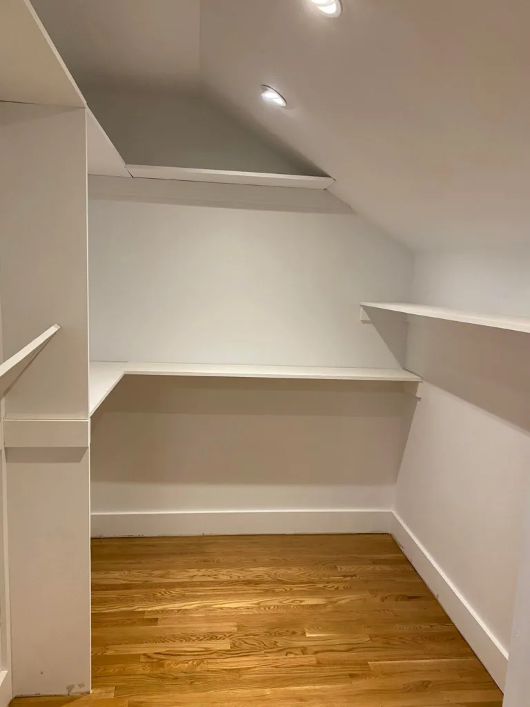 Close-up of the flawless white finish and sturdy wood joints achieved during the closet carpentry and painting.
