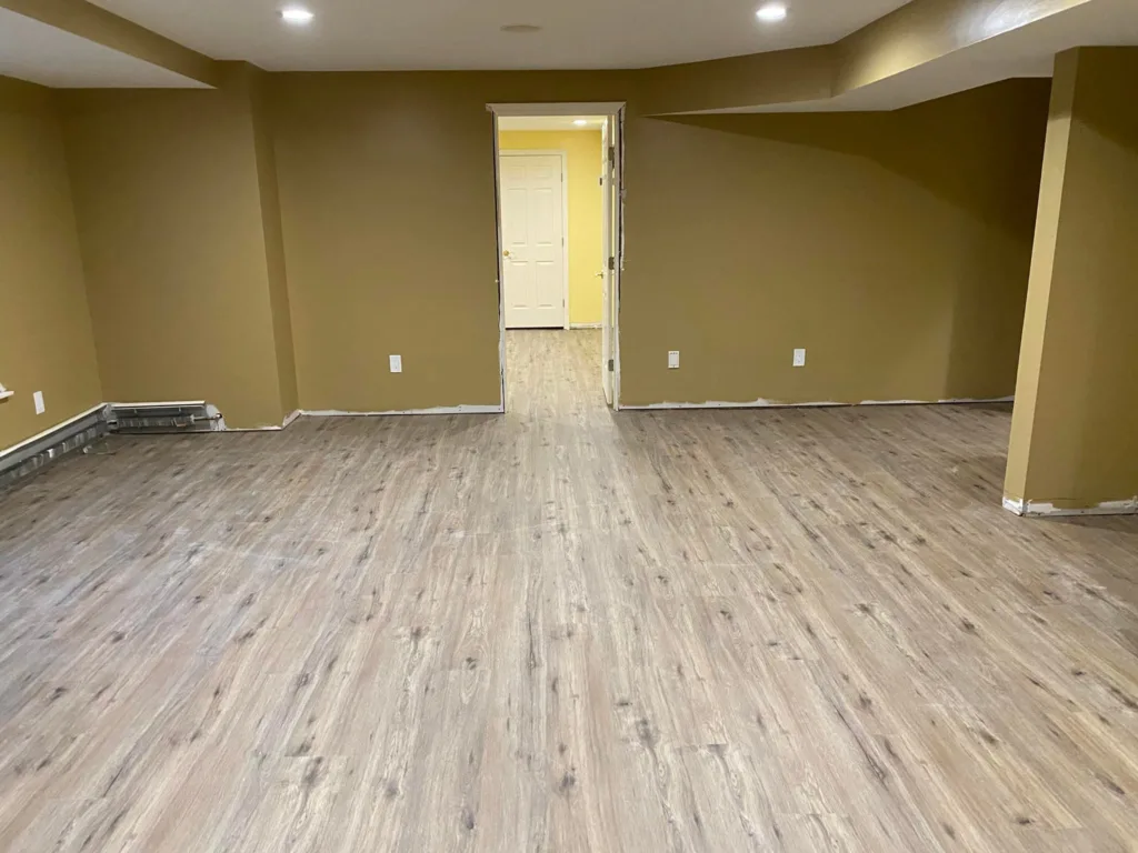 Comprehensive view from a doorway highlighting the uniform finish and layout of a professional basement flooring installation.