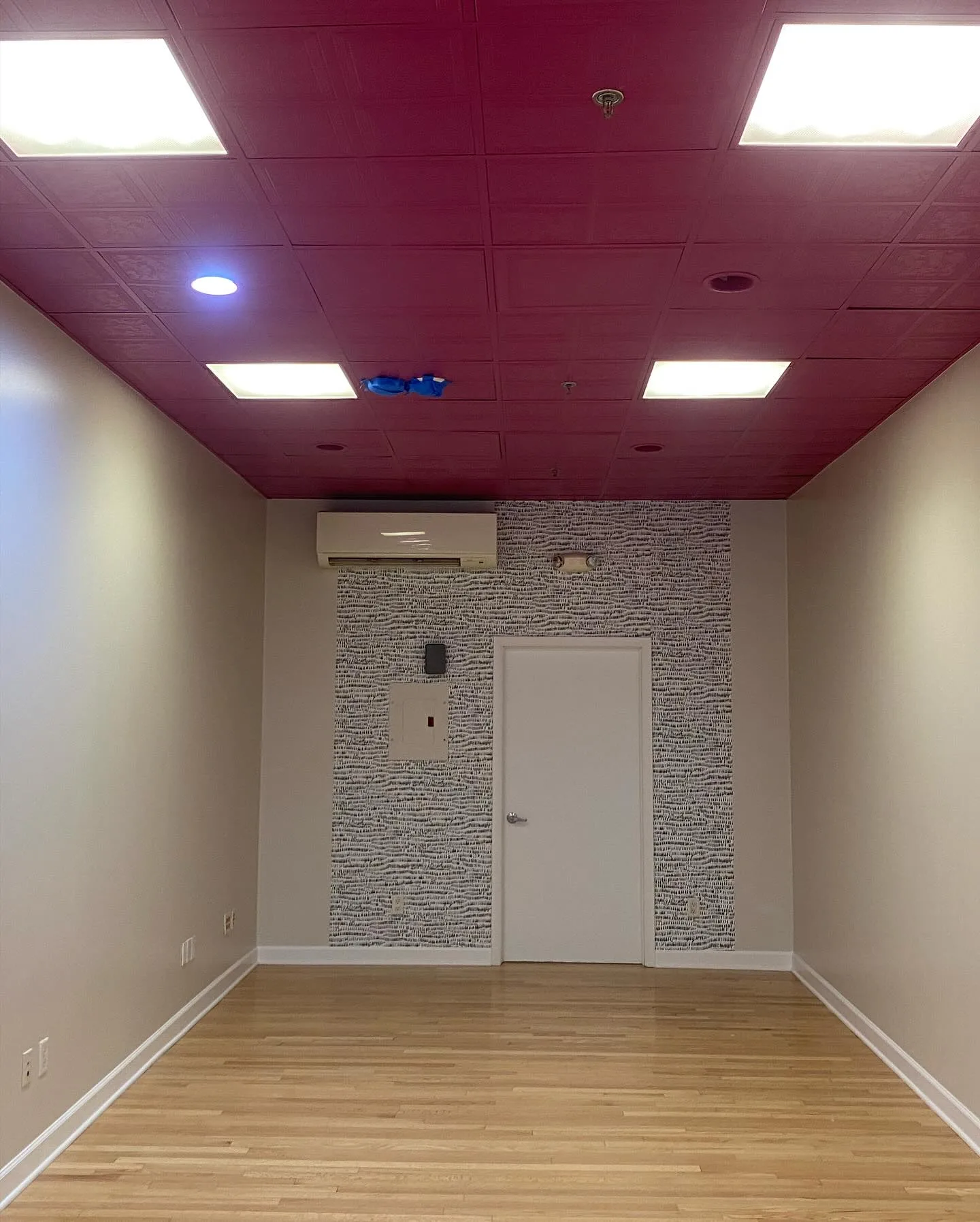 Final result of a studio renovation emphasizing the new commercial flooring and ceiling textures.