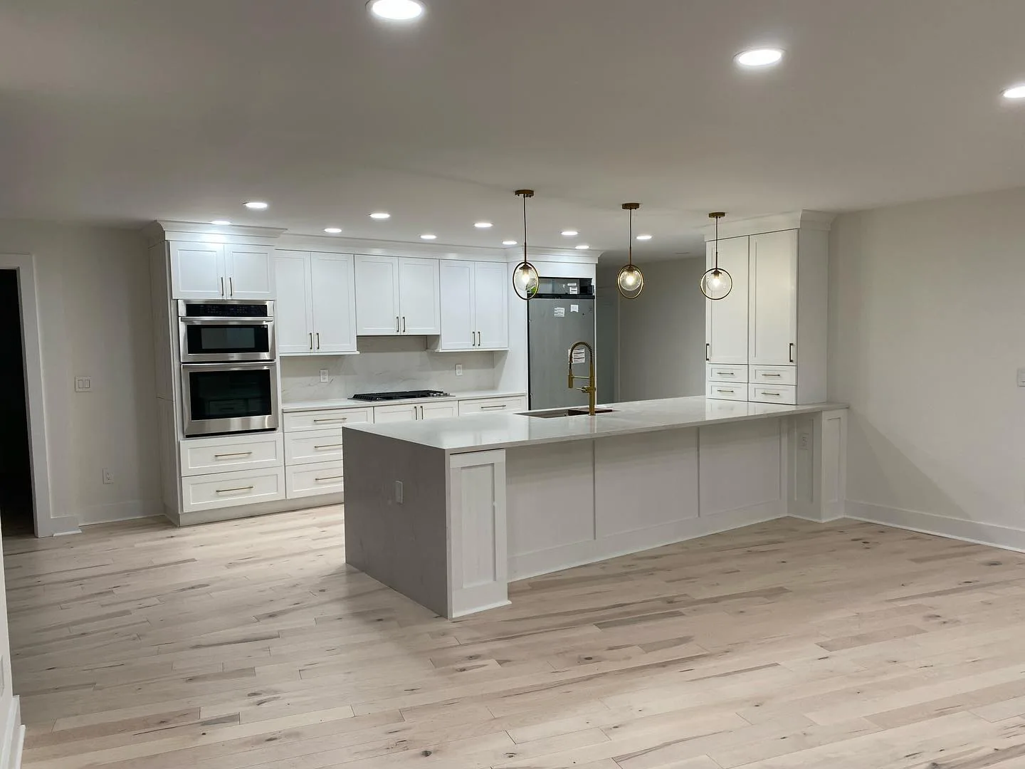 Perspective of an open-concept living area following a complete modern apartment renovation.