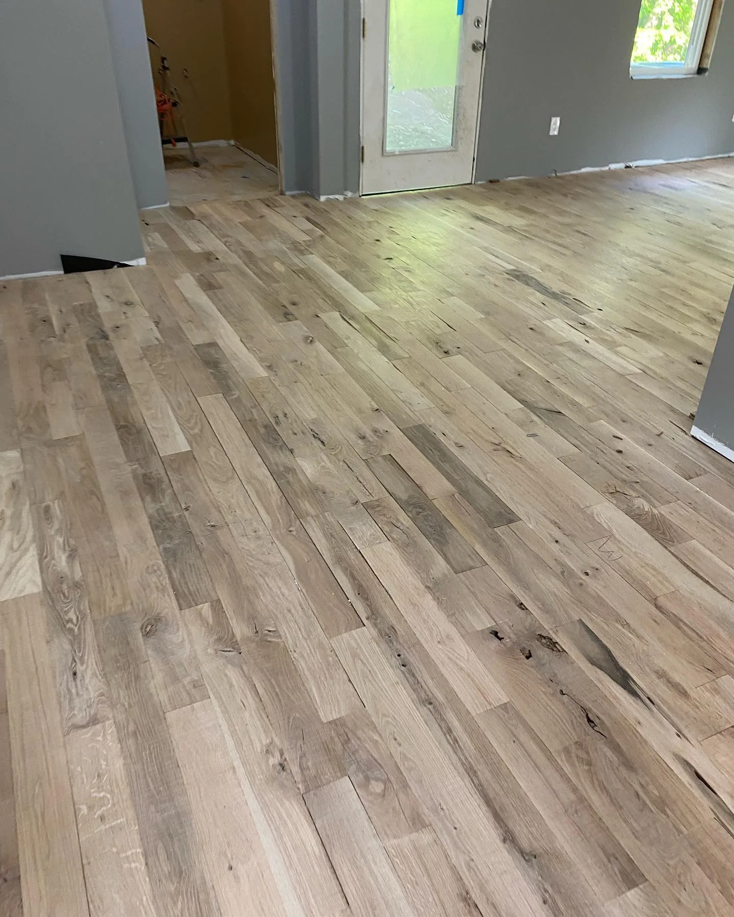 Close-up of the White Oak flooring installation near an entryway illustrating natural wood grain.