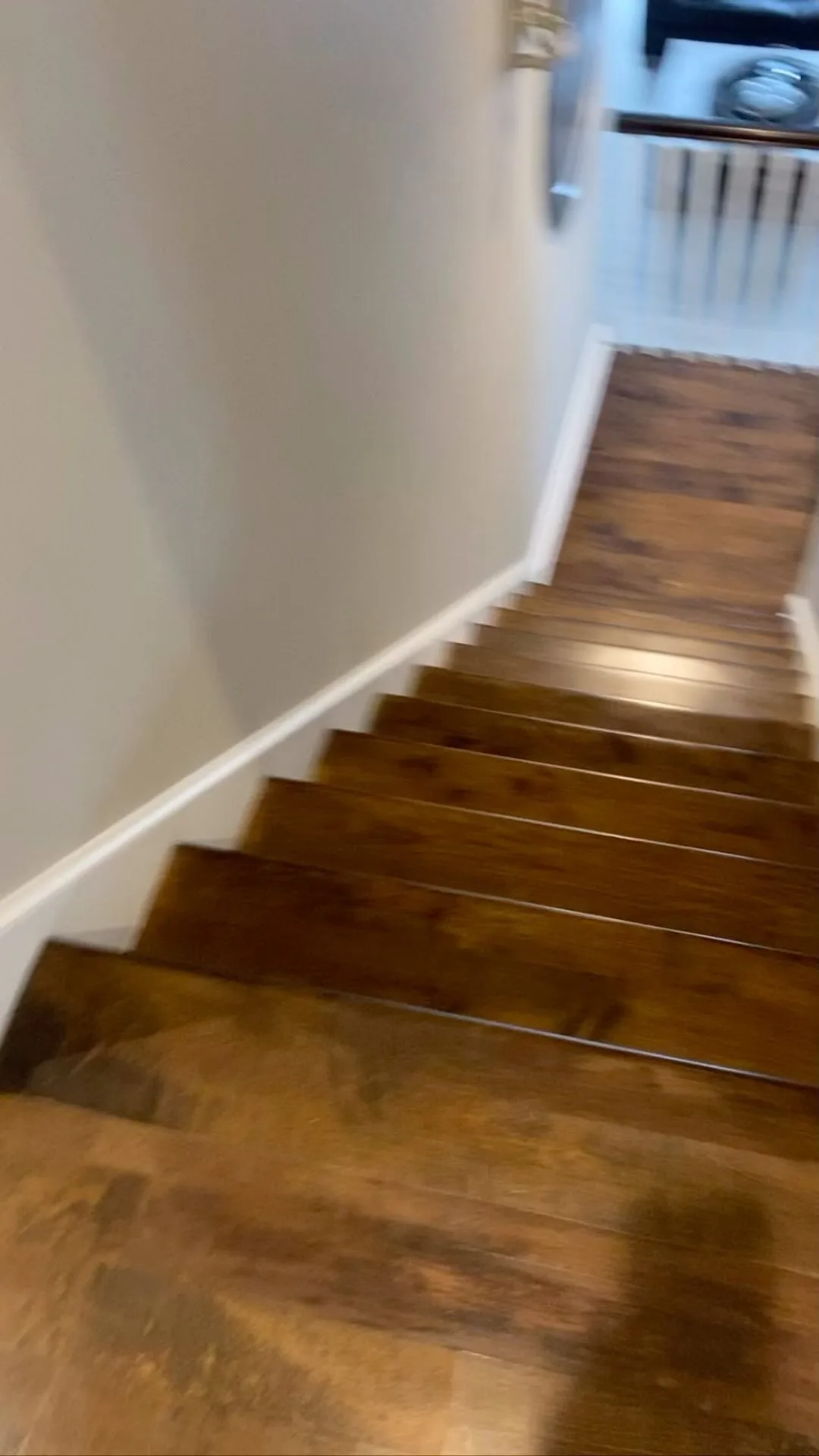 Close-up view of a dark wood flooring installation on a residential staircase.