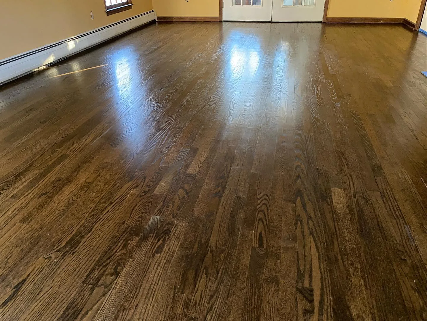 Sanding hardwood floors Ridgefield CT: Wide view of the completed hardwood floor refinishing project in Ridgefield, CT, showing the rich color and sheen.